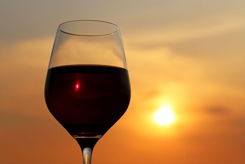 Calice di vino rosso Piwi Valtidone al tramonto. Vini resistenti, viticoltura sostenibile.