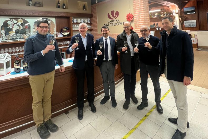 Visita Assessore Mammi a Cantina Valtidone: gruppo di persone con calici di vino, degustazione vini locali e promozione del territorio.