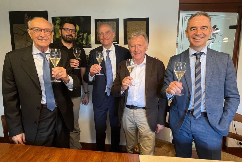 Vertici Banca di Piacenza in visita a Cantina Valtidone, brindisi con spumante locale. Evento enogastronomico e finanziario.